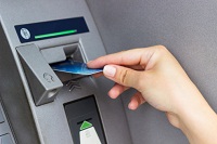 Frau hebt Geld am Geldautomaten ab