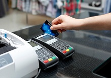 Frau bezahlt im Laden per Kreditkarte