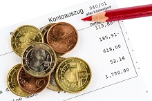 Girokonto: Geldmünzen liegen auf einem Kontoauszug