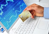 Mann zahlt am Laptop mit Kreditkarte