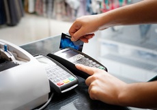 Kreditkarte wird durch ein Zahlungsterminal gezogen