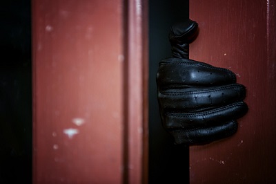 Einbrecher mit Handschuh an der Tür