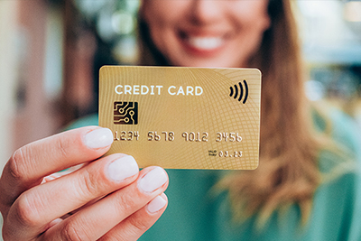 Frau hält goldene Kreditkarte in der Hand