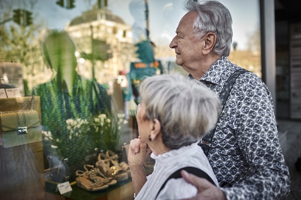 Seniorenpaar betrachtet Auslage in einem Geschäft
