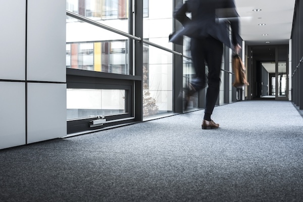 Manager rennt über Flur im Bürogebäude.