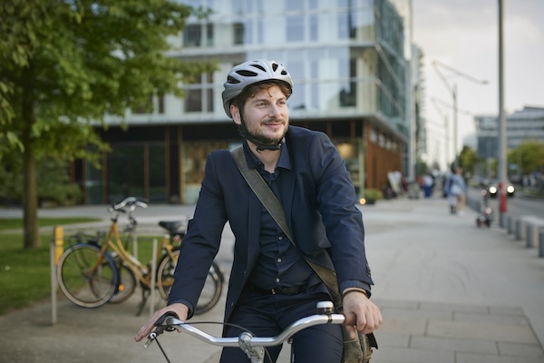 Junger Arbeitnehmer auf Fahhrad in der Stadt.