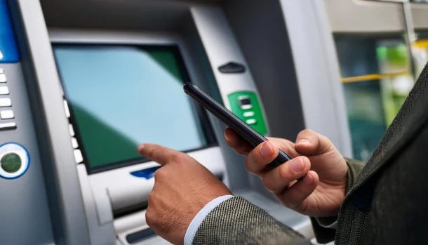 Geld abheben mit der Debitkarte Mann hebt Geld mit Debitkarte ab