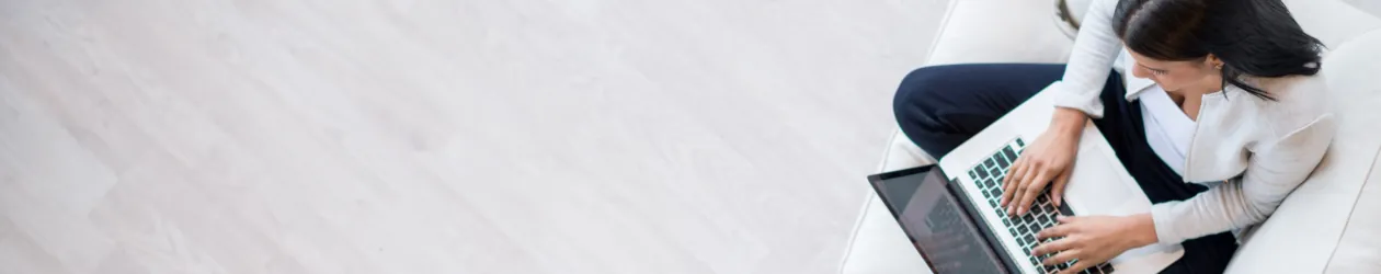 Das VideoIdent-Verfahren erklärt frau-sitzt-mit-laptop-auf-sofa