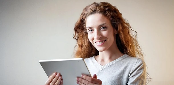 Angebote für die Geldanlage von 50.000 Euro vergleichen und auswählen Frau hält ein Tablet in der Hand