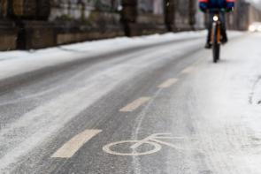 Radfahrer auf schneeglattem Radweg im Winter