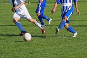 Die meisten Sportunfälle passieren beim Fußball. Fußballspieler beim Spiel auf Rasen.