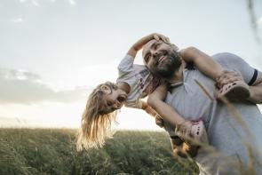 Vater spielt mit Tochter in der Natur.